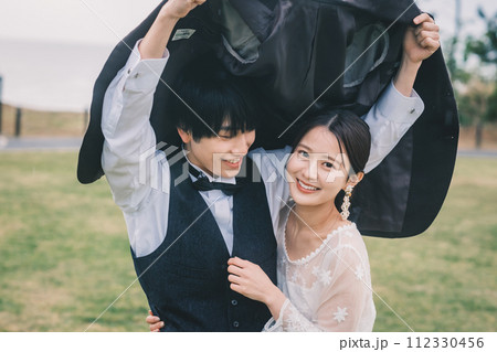 屋外で雨の中寄り添う男女 112330456