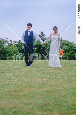 公園で手を繋いでいる新郎新婦 112330660