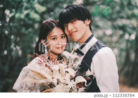 ブーケを持ち寄り添う新郎新婦 ブーケを持ち寄り添う新郎新婦 112330764