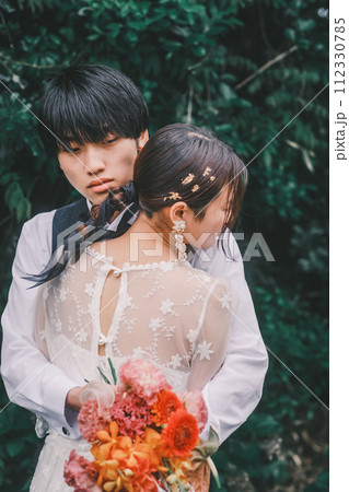 リゾート地でハグする新郎新婦 112330785