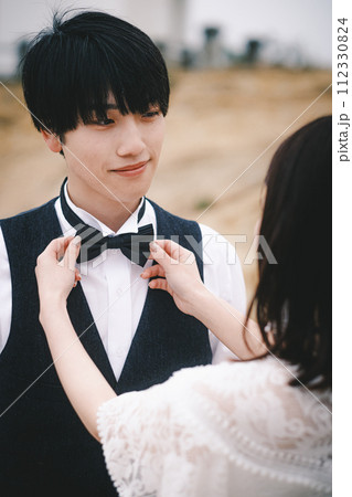 新婦にネクタイを締めてもらう新郎 新婦にネクタイを締めてもらう新郎 112330824