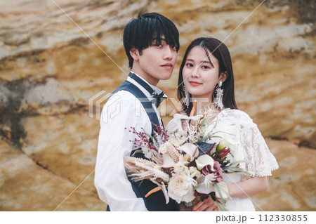 岩場で寄り添う新郎新婦 岩場で寄り添う新郎新婦 112330855