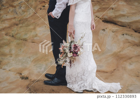 岩場で背中合わせに立つ新郎新婦 岩場で背中合わせに立つ新郎新婦 112330893