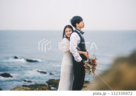 海岸で寄り添う新郎新婦 112330972