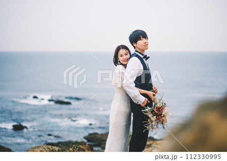 海岸で寄り添う新郎新婦 112330995