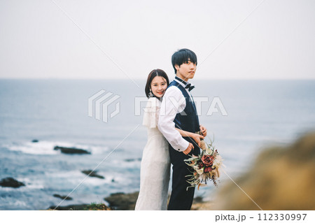 海岸で寄り添う新郎新婦 海岸で寄り添う新郎新婦 112330997