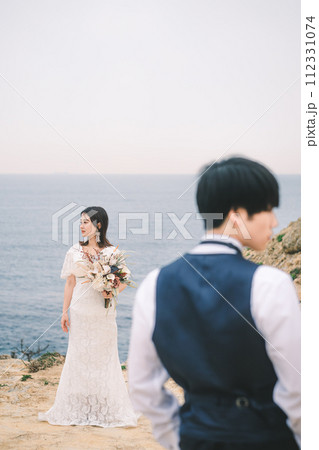 海岸で対面する新郎新婦 海岸で対面する新郎新婦 112331074