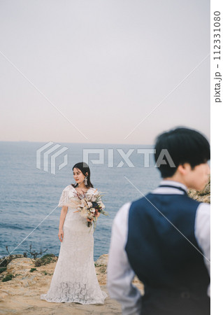海岸で対面する新郎新婦 112331080