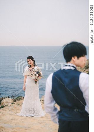 海岸で対面する新郎新婦 112331083