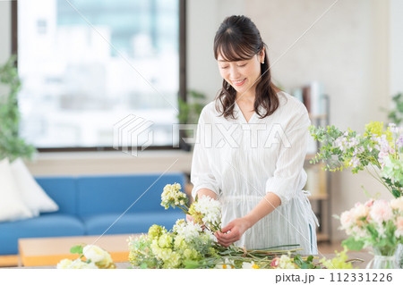 リビングで趣味のフラワーアレンジメントをするミドルの女性 112331226