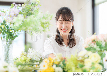 リビングで趣味のフラワーアレンジメントをするミドルの女性 112331248