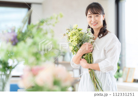 リビングで趣味のフラワーアレンジメントをするミドルの女性 112331251