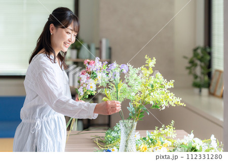 リビングで趣味のフラワーアレンジメントをするミドルの女性 112331280