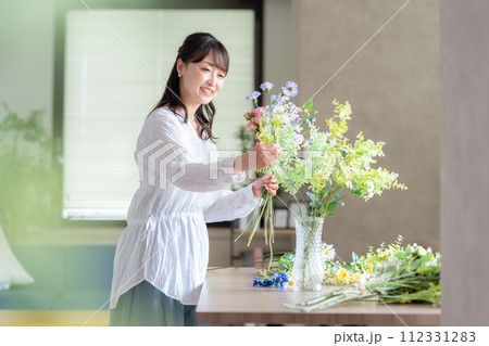 リビングで趣味のフラワーアレンジメントをするミドルの女性 リビングで趣味のフラワーアレンジメントをするミドルの女性 112331283
