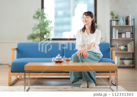 リビングで紅茶を飲むミドルの女性 112331303