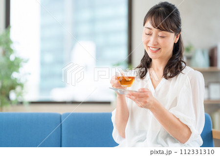 リビングで紅茶を飲むミドルの女性 112331310