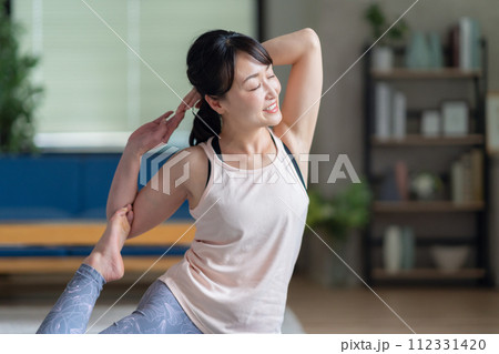 リビングでヨガをするミドルの女性 112331420