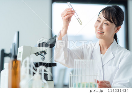 顕微鏡を覗いて研究、実験をするミドルの女性 顕微鏡を覗いて研究、実験をするミドルの女性 112331434