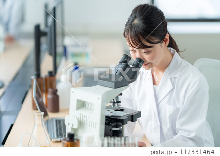 顕微鏡を覗いて研究、実験をするミドルの女性 112331464