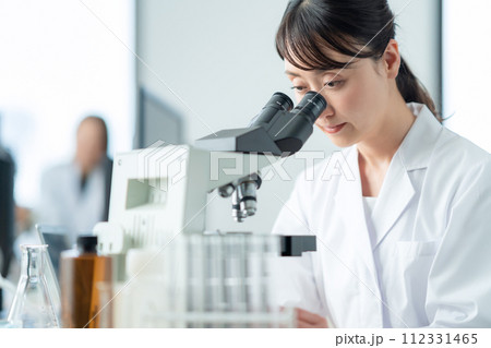 顕微鏡を覗いて研究、実験をするミドルの女性 112331465