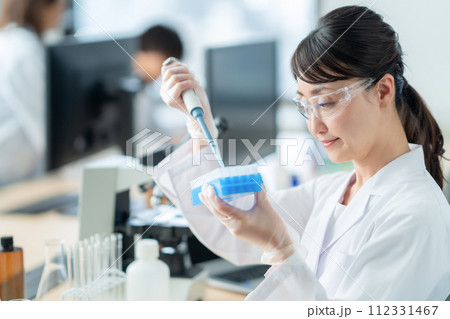 ピペットを使って研究、実験をするミドルの女性 112331467