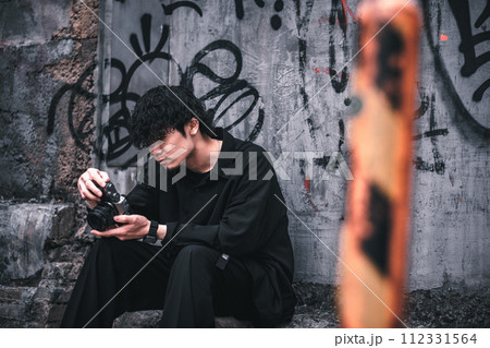 座って撮った写真を確認する男性 座って撮った写真を確認する男性 112331564