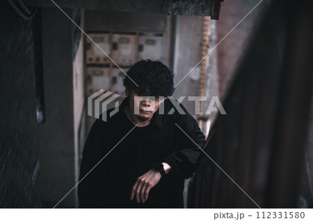 古びたマンションの階段に立つ男性 112331580