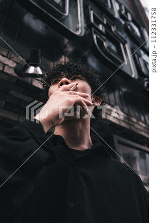 屋外でタバコを吸ってる男性 112331758