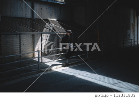 高架下で腰掛ける男性 高架下で腰掛ける男性 112331935