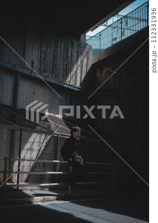 高架下で腰掛ける男性 高架下で腰掛ける男性 112331936
