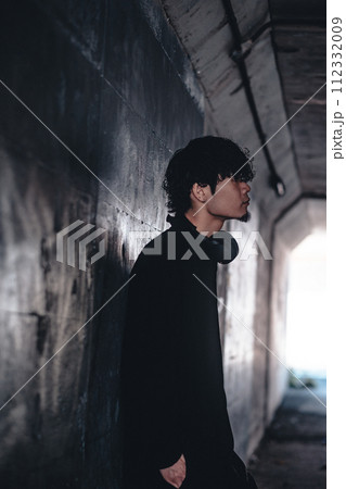 高架下でヘッドフォンをつけてる男性 112332009