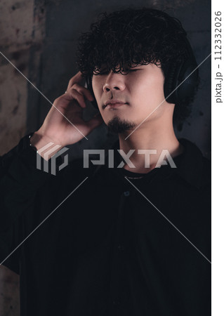 高架下でヘッドフォンをつけてる男性 112332026