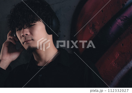 高架下でヘッドフォンをつけてる男性 高架下でヘッドフォンをつけてる男性 112332027