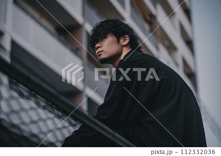 街で待ち合わせをするヘッドフォンをしたオシャレな男性 112332036