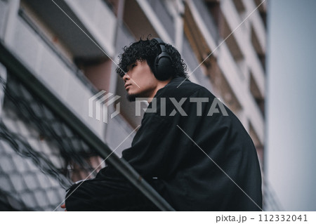 街で待ち合わせをするヘッドフォンをしたオシャレな男性 112332041