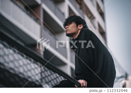 街で待ち合わせをするヘッドフォンをしたオシャレな男性 街で待ち合わせをするヘッドフォンをしたオシャレな男性 112332046