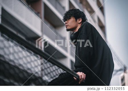 街で待ち合わせをするヘッドフォンをしたオシャレな男性 112332055