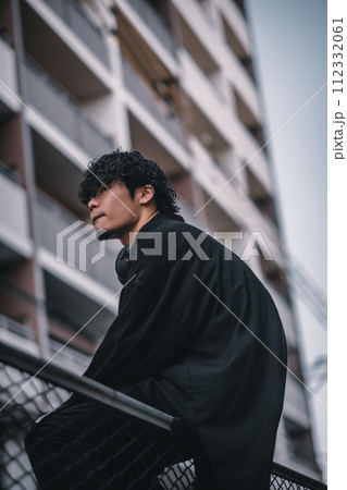 街で待ち合わせをするヘッドフォンをしたオシャレな男性 112332061