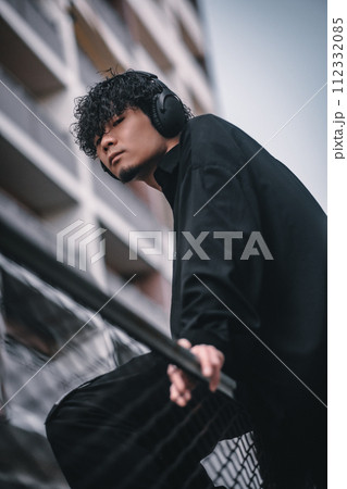 街で待ち合わせをするヘッドフォンをしたオシャレな男性 街で待ち合わせをするヘッドフォンをしたオシャレな男性 112332085