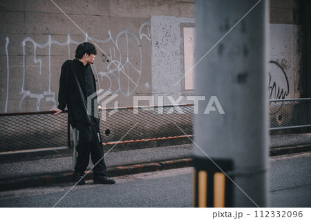 路地裏で佇む男性 112332096