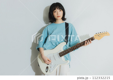 リビングでギターを弾く女性 112332215