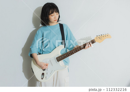 リビングでギターを弾く女性 112332216