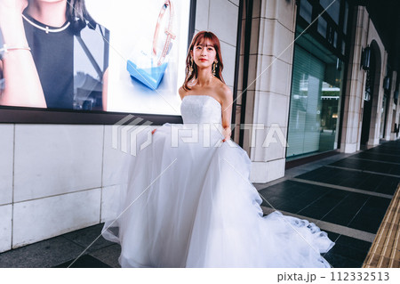 街をウエディングドレスを持って歩く花嫁 街をウエディングドレスを持って歩く花嫁 112332513