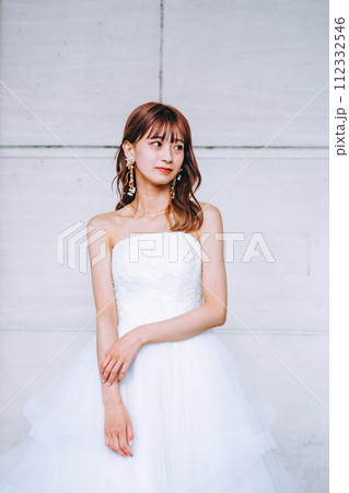 白い壁の前に立つ花嫁 112332546