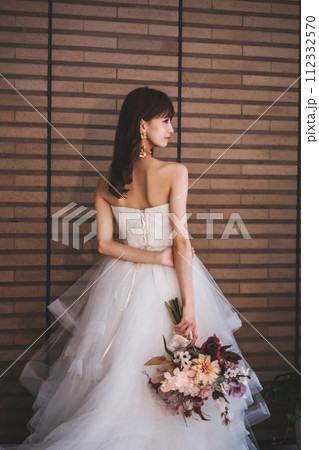 ブーケを持ってポージングするウエディングドレスを着た花嫁 ブーケを持ってポージングするウエディングドレスを着た花嫁 112332570
