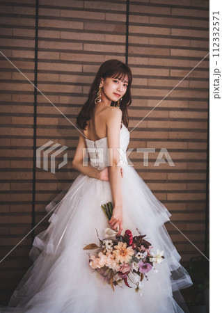 ブーケを持ってポージングするウエディングドレスを着た花嫁 ブーケを持ってポージングするウエディングドレスを着た花嫁 112332571