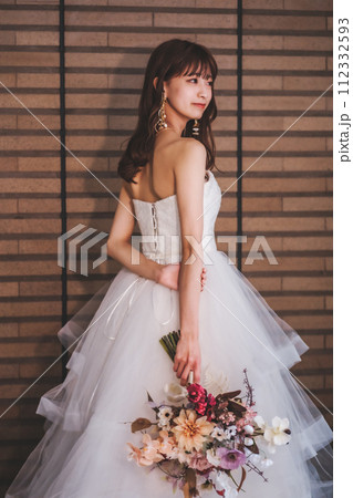 ブーケを持ってポージングするウエディングドレスを着た花嫁 ブーケを持ってポージングするウエディングドレスを着た花嫁 112332593