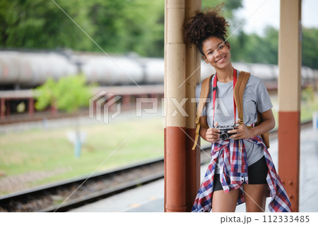 Young Asian African woman traveler with backpack in the railway train station, traveler girl walking stand sit waiting take a picture on railway platform train station. High quality photo Young Asian African woman traveler with backpack in the railway train station, traveler girl walking stand sit waiting take a picture on railway platform train station. High quality photo 112333485