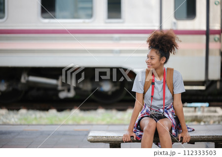 Young Asian African woman traveler with backpack in the railway train station, traveler girl walking stand sit waiting take a picture on railway platform train station. High quality photo Young Asian African woman traveler with backpack in the railway train station, traveler girl walking stand sit waiting take a picture on railway platform train station. High quality photo 112333503