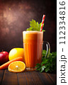 A refreshing orange and carrot smoothie in a tall mug, garnished with parsley on a wooden surface. 112334816